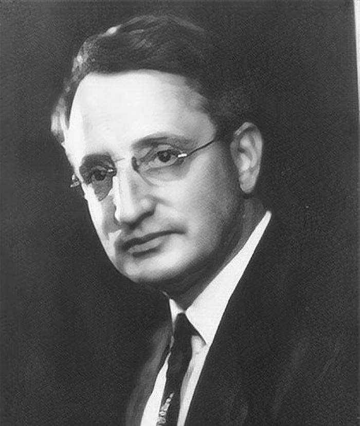 black and white portrait of Frank Benford, with short hair, glasses, no beard, suit and tie